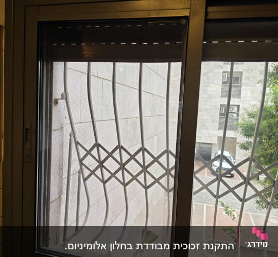 חלון עם סורגי מתכת ונוף חיצוני